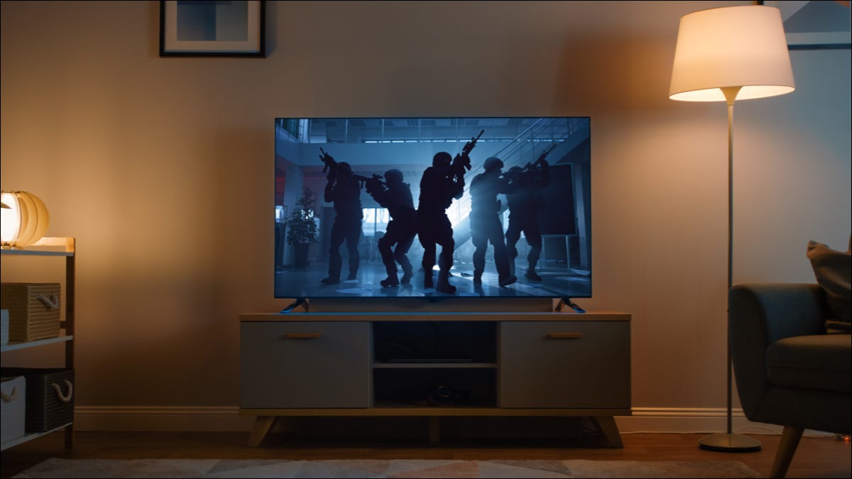 Un televisor que muestra una película de acción oscura en una sala de estar.