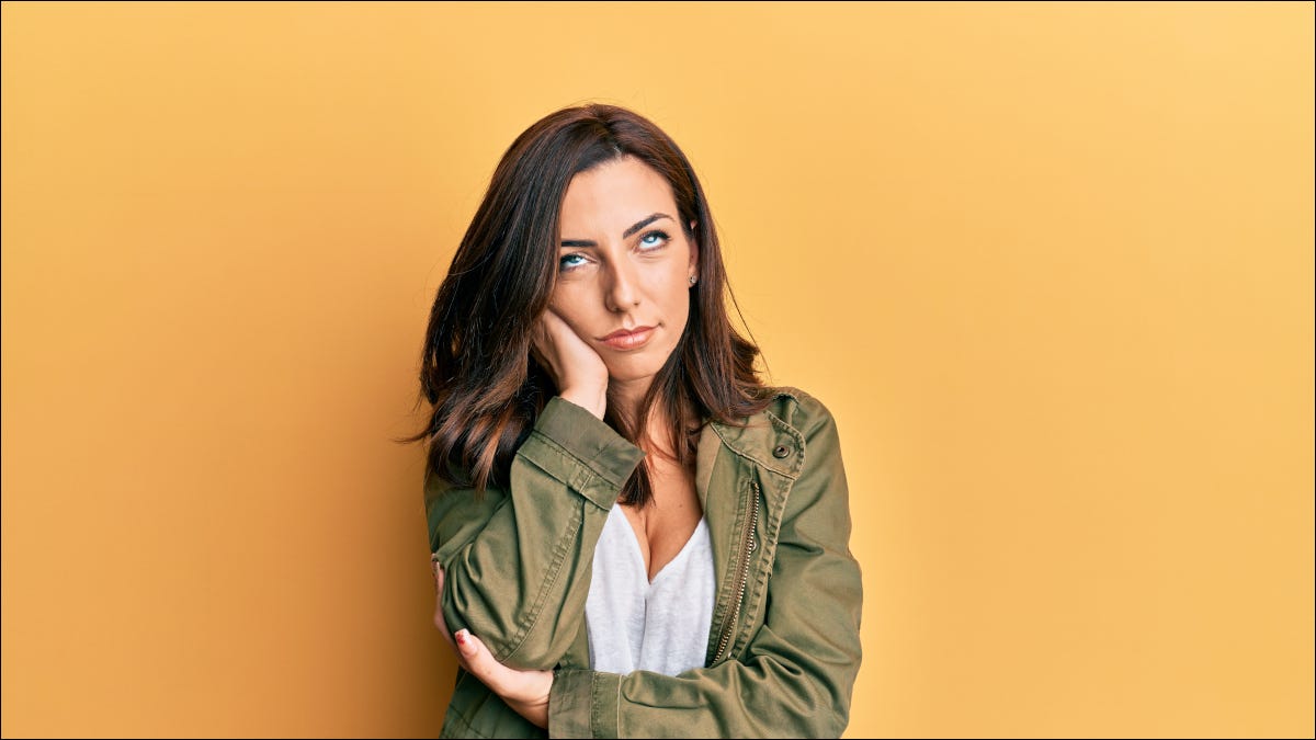 Mujer joven con la mano en la cabeza, ojos en blanco y aspecto cansado